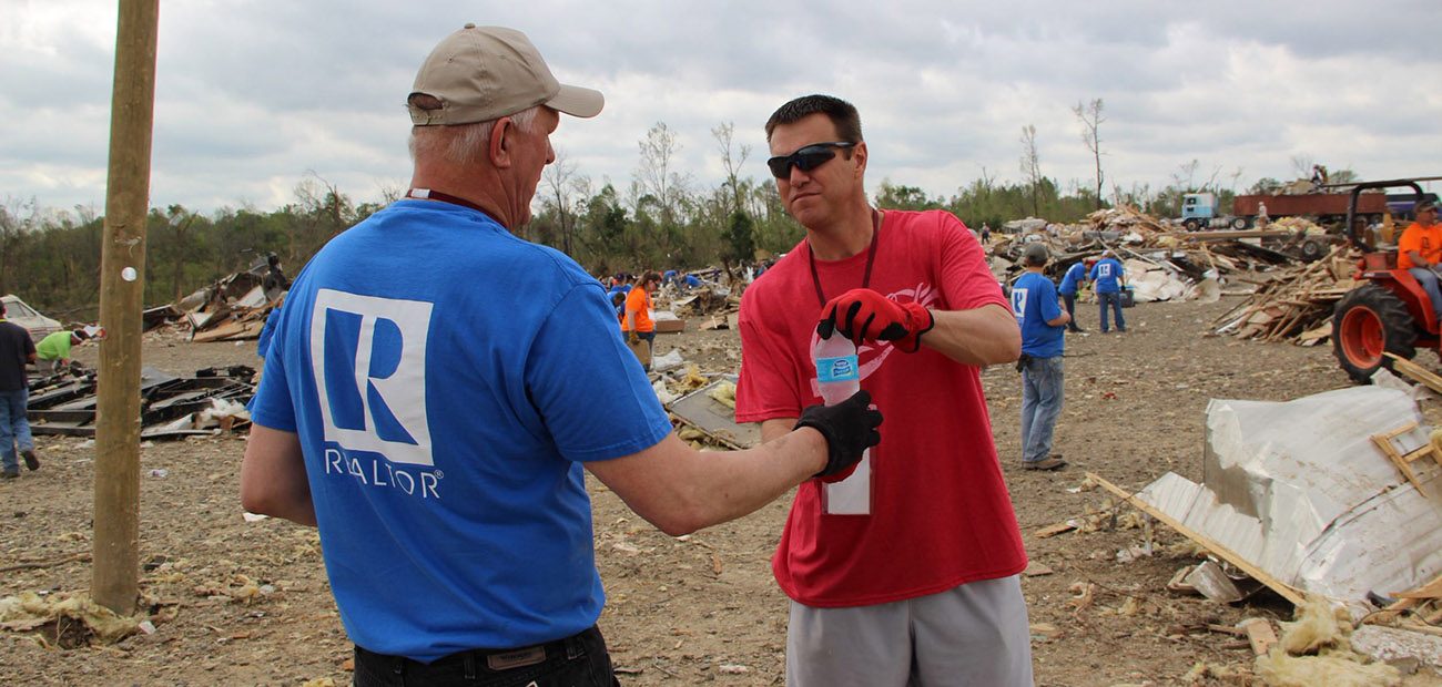 2014 Arkansas REALTORS® President Bill Ladd (left) handed out water to tornado cleanup volunteers.