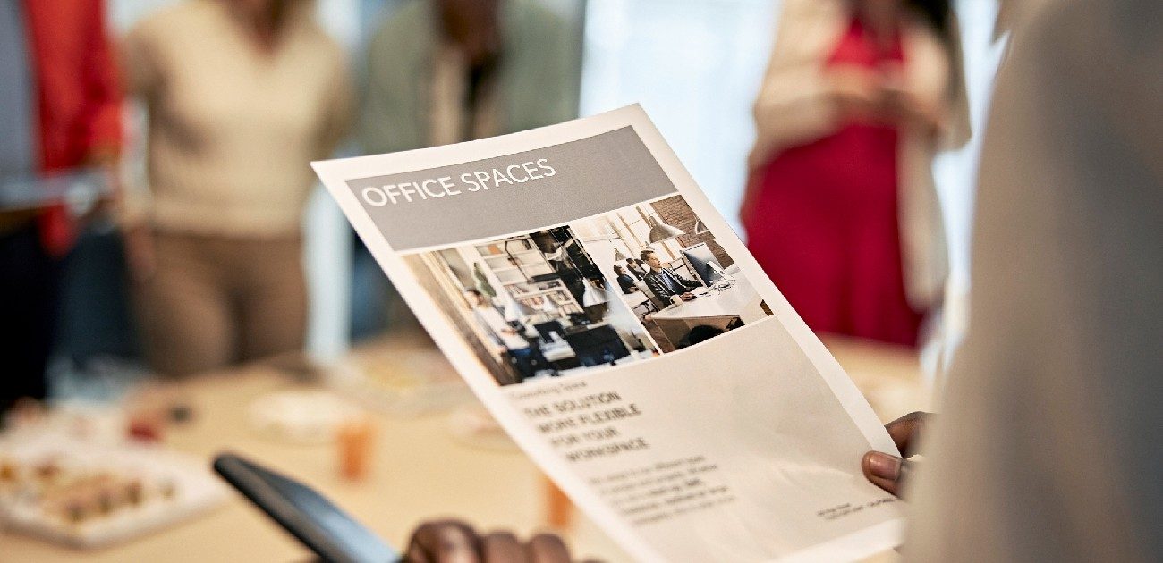 A picture of a person holding a flyer advertising office space.