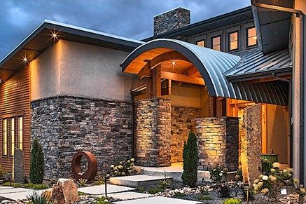 A picture of the front of a home with a curved roof near the front door, a new trend in home design.