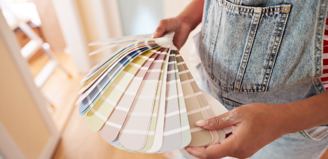 A person fanning out a paint color palette book. 