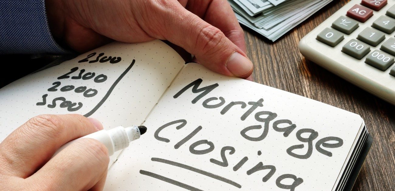 An open notebook with "Mortgage Closing" written on the visible page.