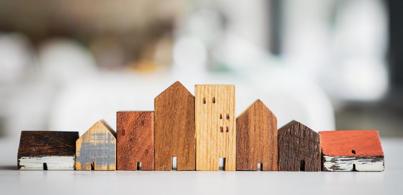 A row of wooden house miniatures of varying styles and complexity.