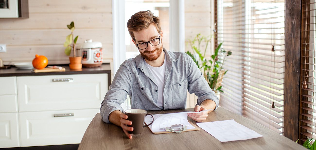 man reviewing paperwork in kitchen