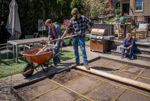 Family constructing backyard garden
