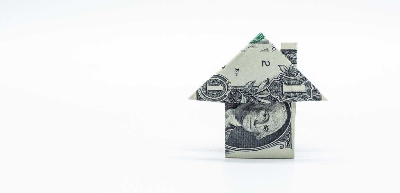 A dollar bill folded into a depiction of a house