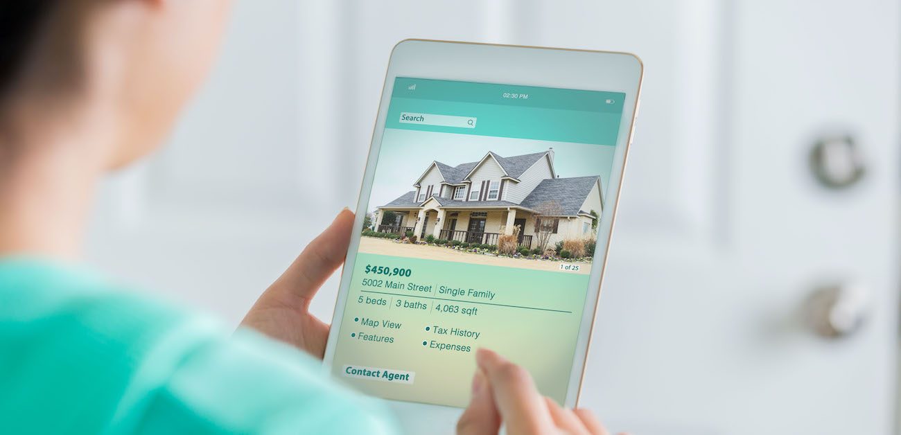 Woman looking at home listing on tablet