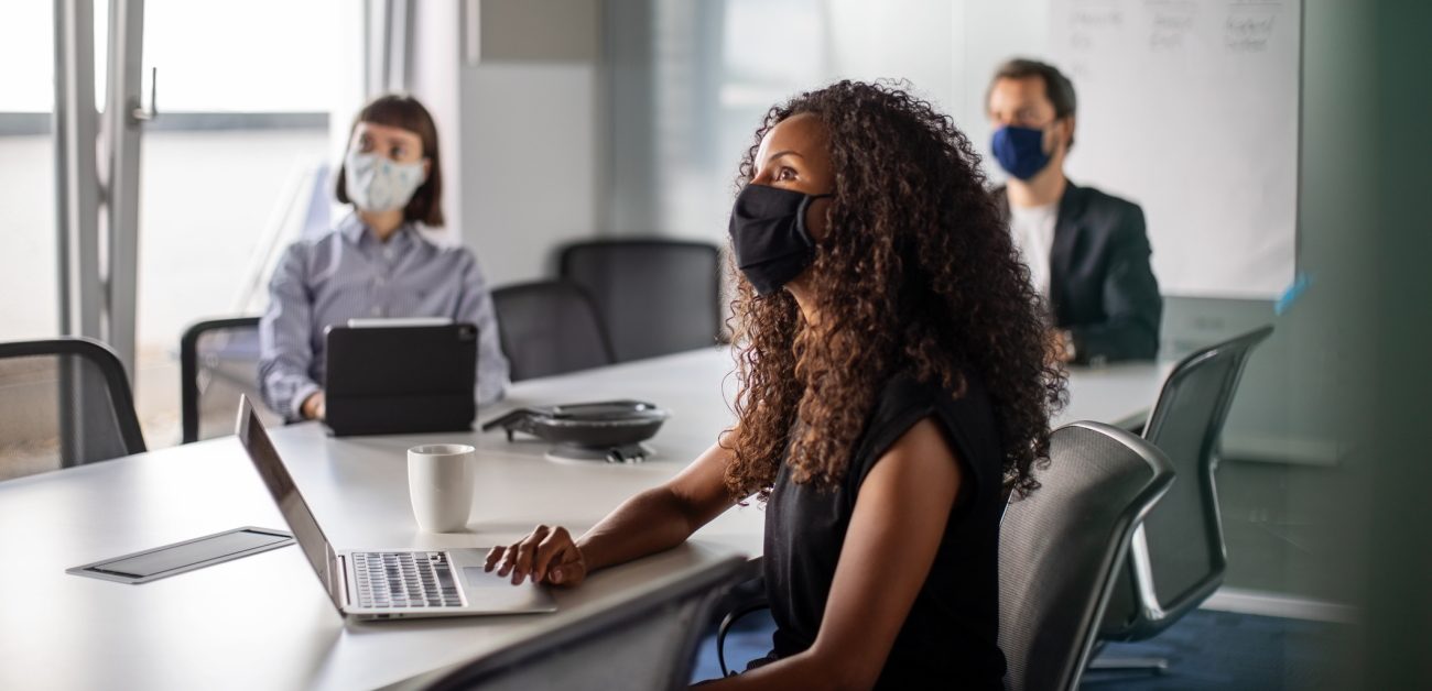People wearing masks in a meeting room