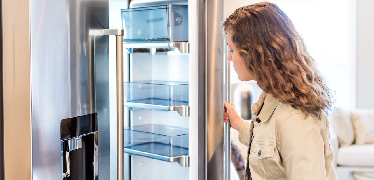 Woman looking inside new refrigerator 