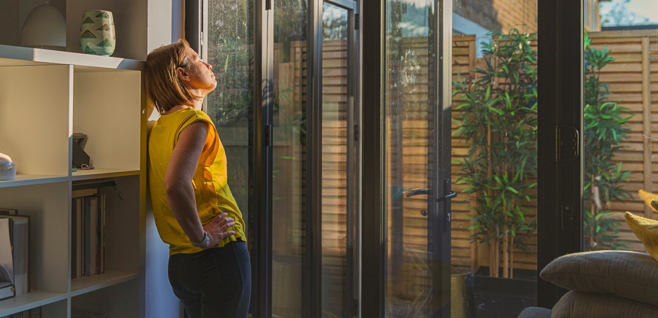 Woman enjoying sunlight through her home's windows