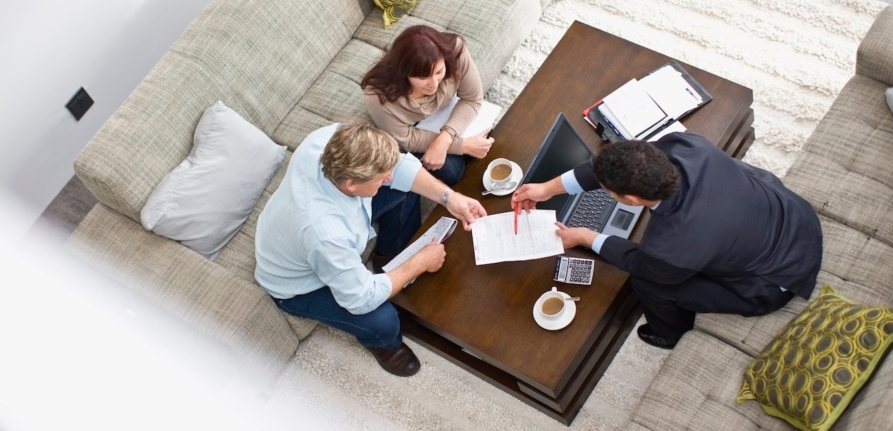 Real estate agent sitting down with clients to go over paperwork