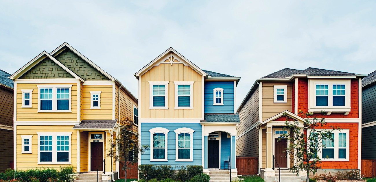 A picture of three single-family homes, each one painted in varying, bold colors.