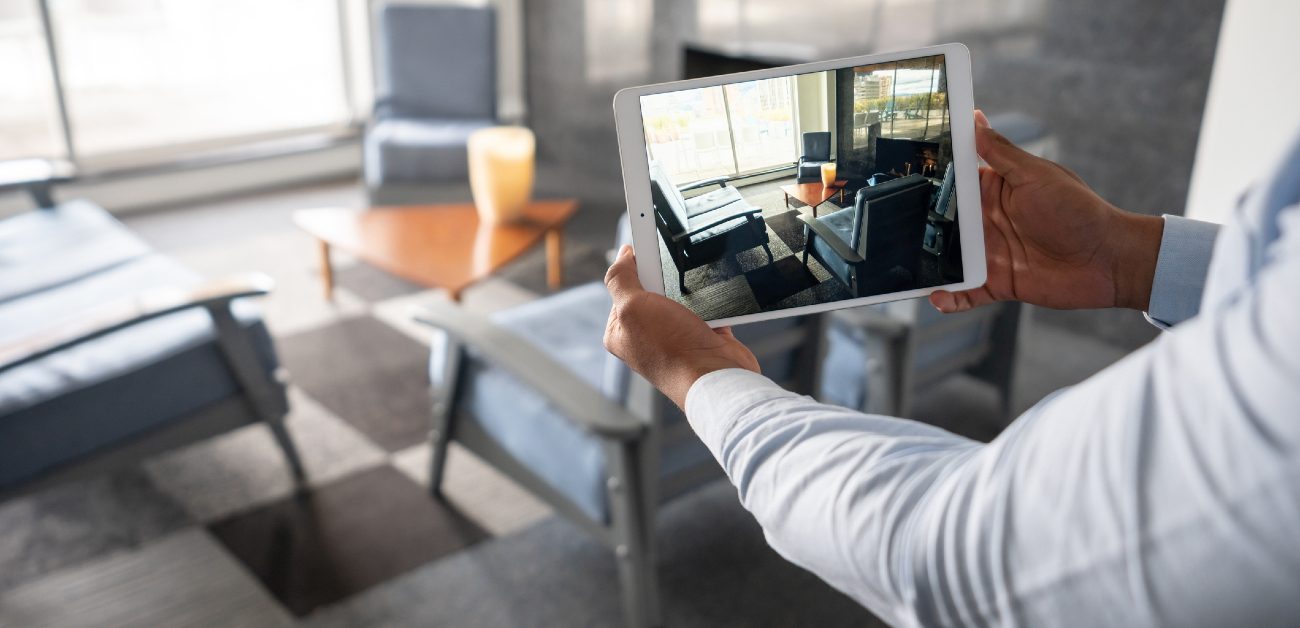 A person holding a tablet taking an image of a living room they're standing in.
