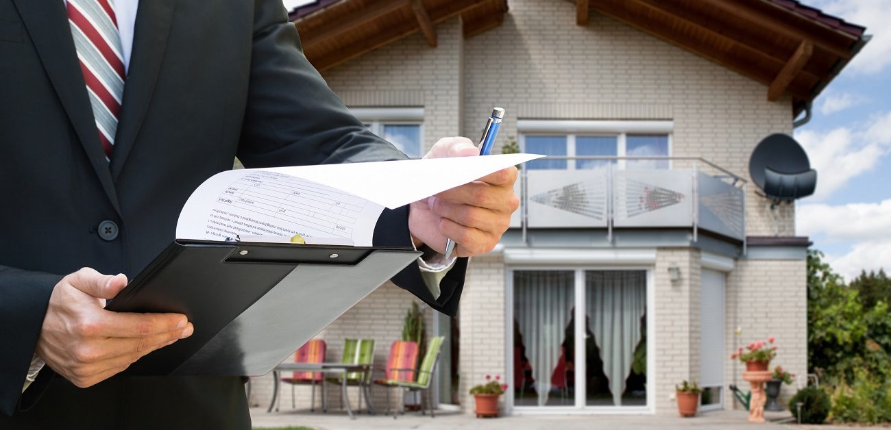 Man Checking Documents Standing Near House