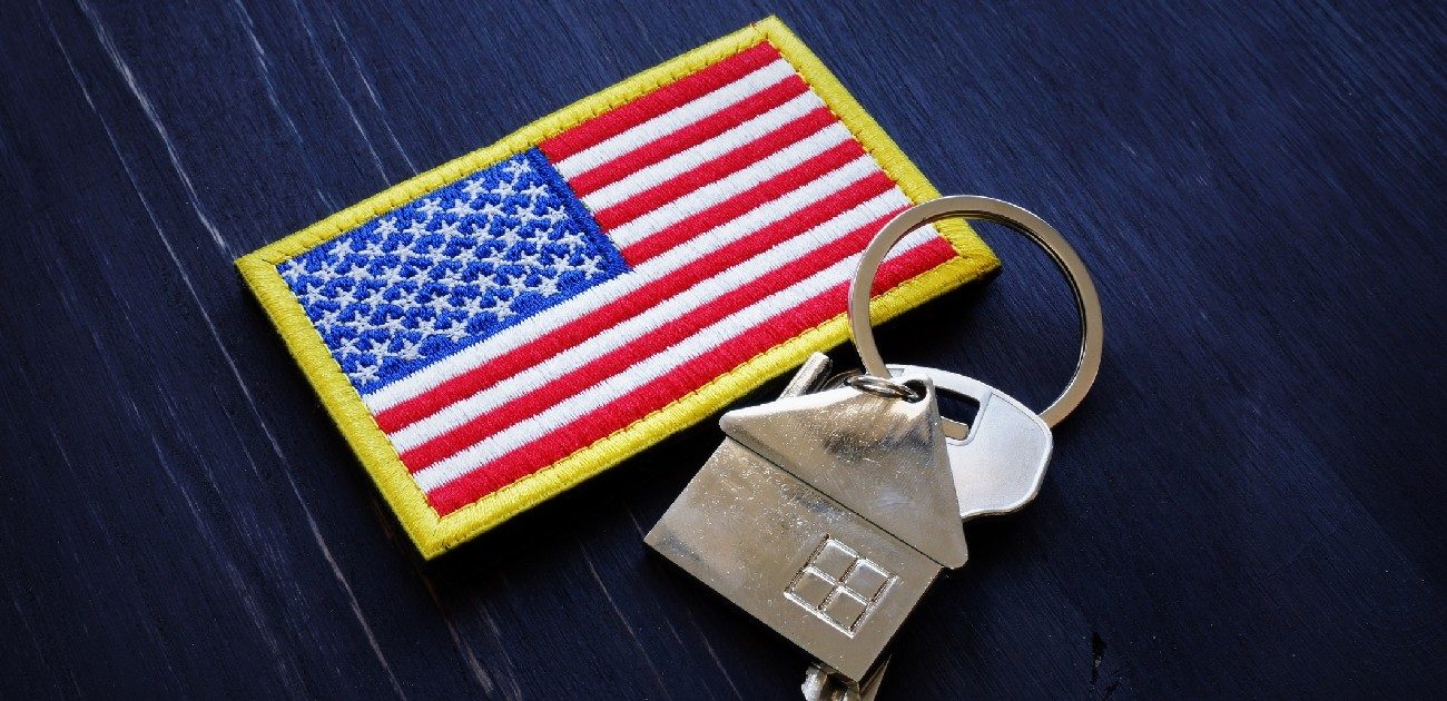 A picture of an American flag patch and a set of house keys on a dark blue background.