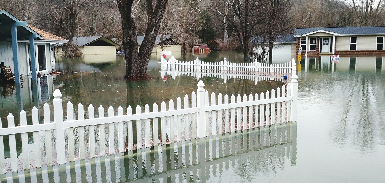 Fence In Water Amidst Houses During Flood