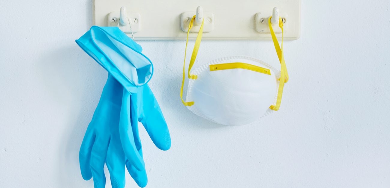 gloves and mask hanging on coat rack