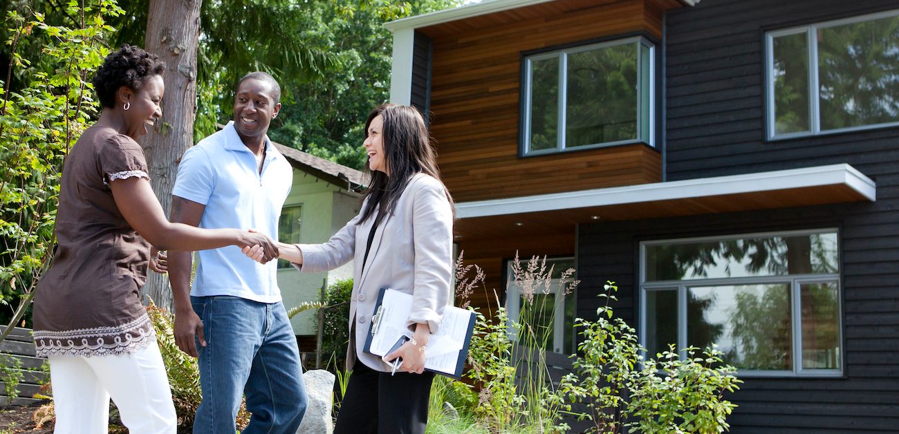 African American couple meeting real estate agent to look at home