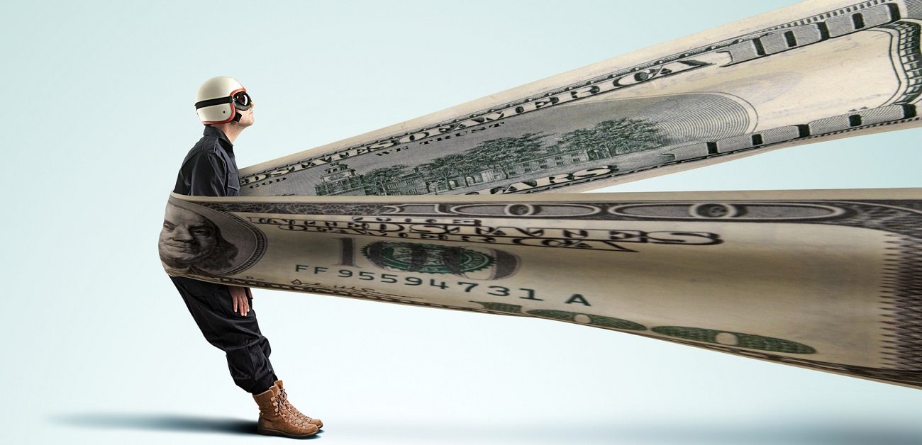 Man in a slingshot made of a hundred dollar bill